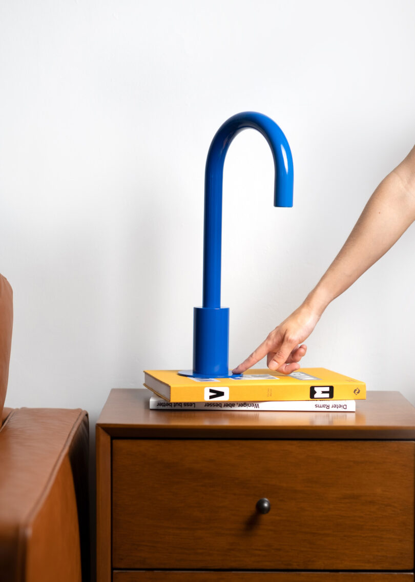 hand turning on blue faucet lamp